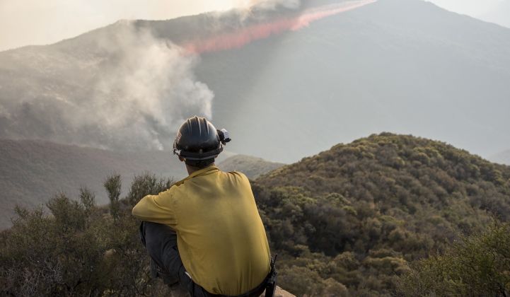 A firefighter watches a 2017 blaze in California. (California National Guard/Flickr)